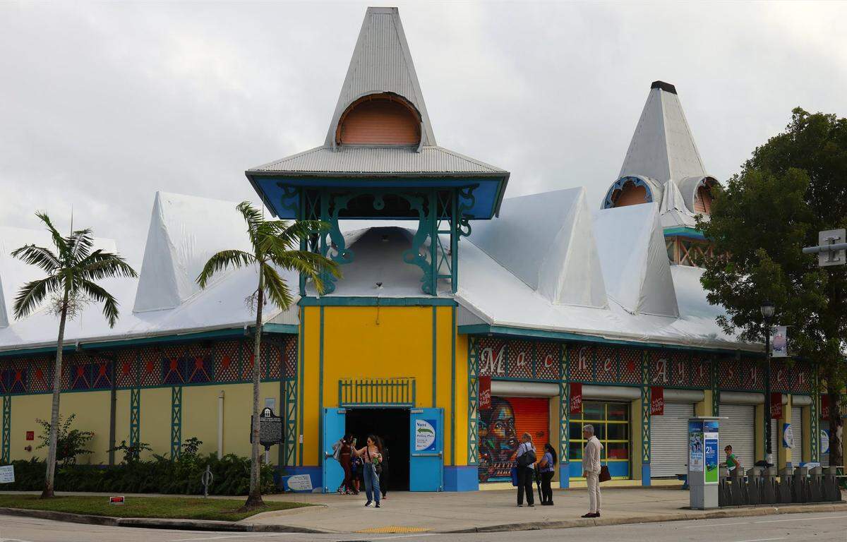 Caribbean Marketplace in Little Haiti has its roof covered in white plastic to prevent leaking. The property needs extensive maintenance and improvements, including a new roof.