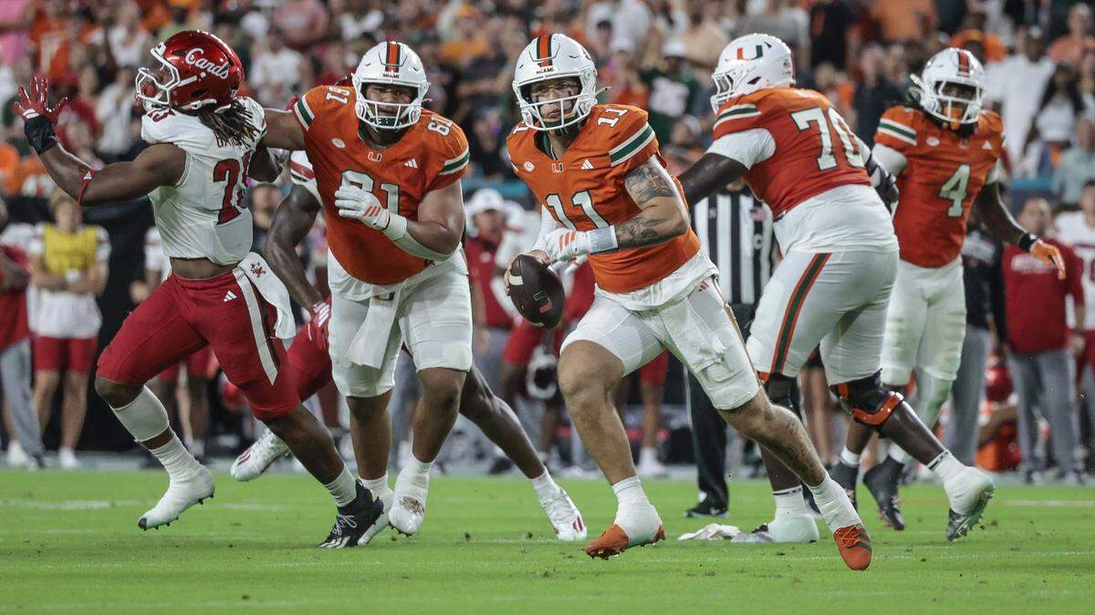 Miami Hurricanes quarterback Carson Beck (11) scrambles in the first half during the NCAA football game against the Louisville Cardinals at Hard Rock Stadium in Miami Gardens, Florida, on Friday, October 17, 2025. 