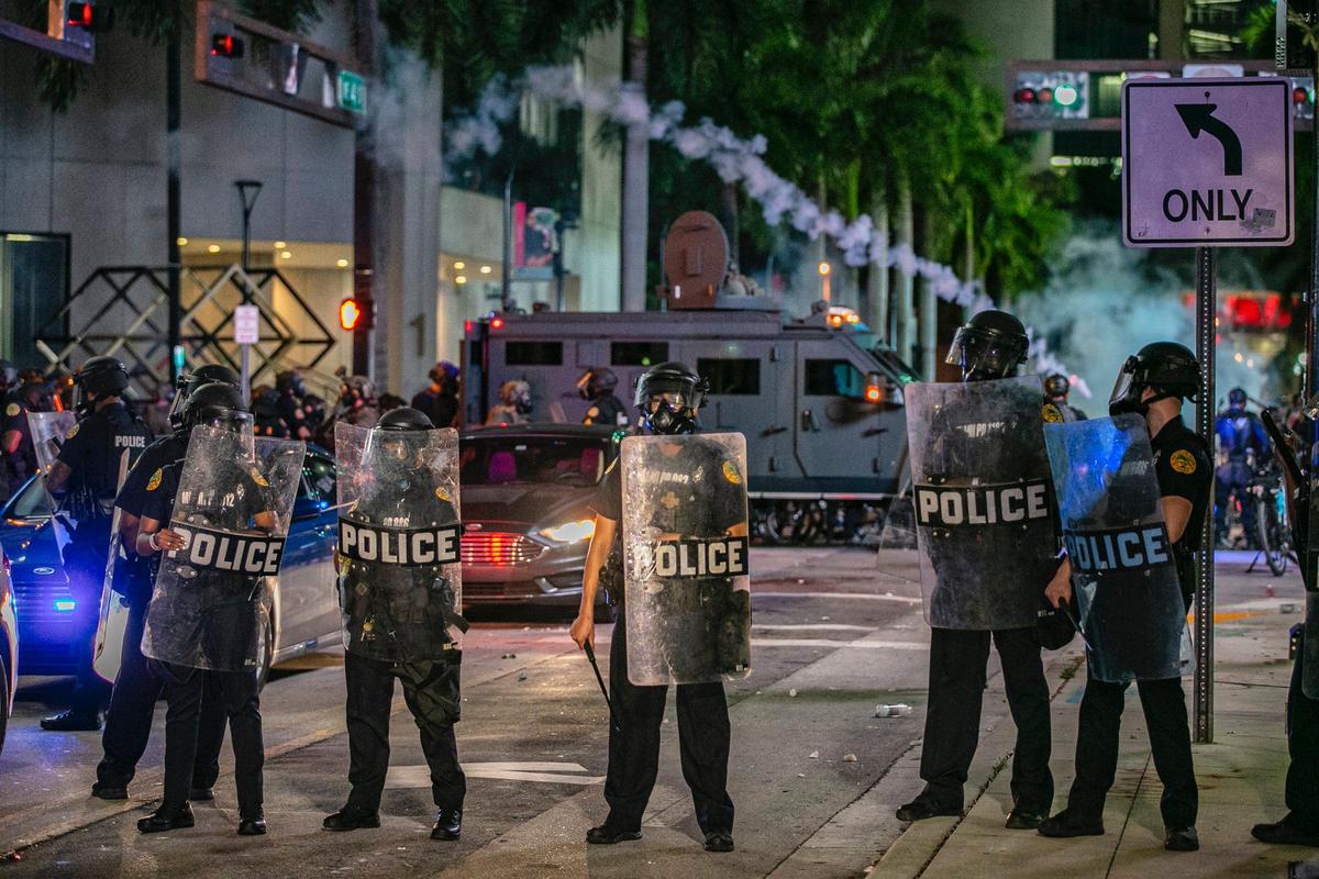 City of Miami Police officers fire tear gas as they try to clear the streets of protesters at the McDonald’s restaurant across from Miami Dade College during a George Floyd protest in downtown Miami on Saturday, May 30, 2020.