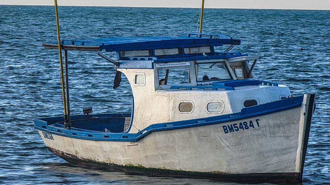 A fishing boat floats in shallow water off Key West Thursday, March 24, 2022. The U.S. Border Patrol said 15 people from Cuba arrived in the vessel earlier that day.