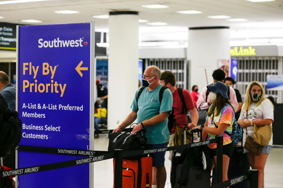 Travelers flying with Southwest Airlines wait in line for check-in inside Concourse G at Miami International Airport in Miami, Florida, on Friday, August 6, 2021.