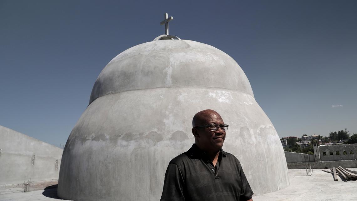Father Jean Jacques Frédéric poses near the dome of Notre-Dame du Perpétuel Secours.