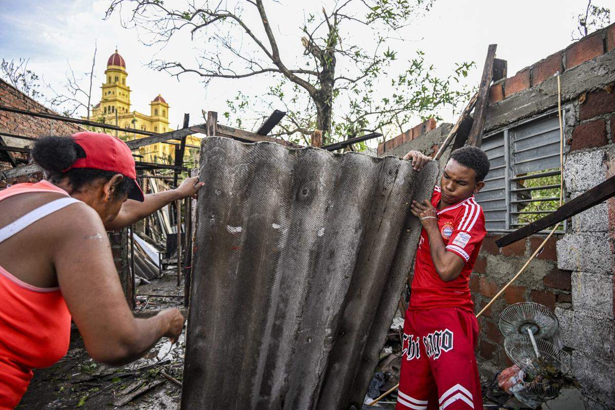 Residents of El Cobre, in the province of Santiago de Cuba, recover parts of their damaged house after the passage of Hurricane Melissa, on October 29, 2025. 