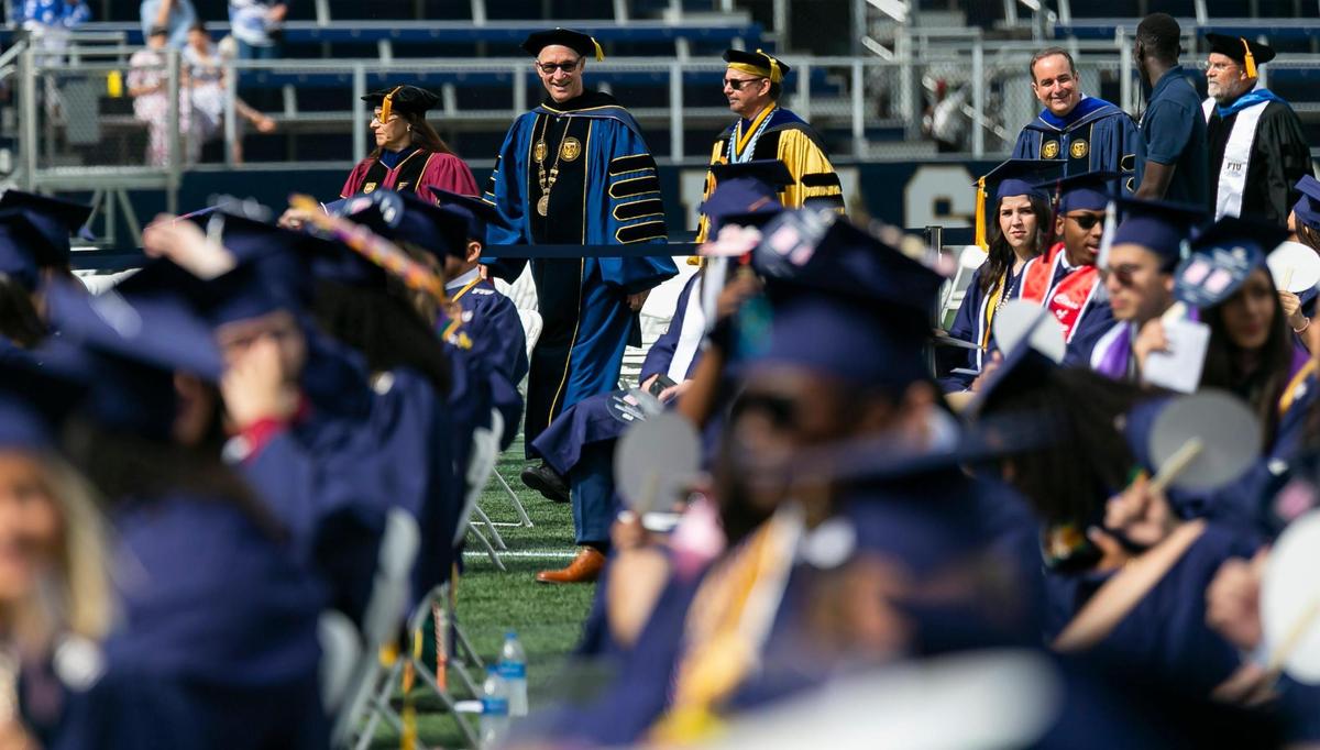 Florida International University Interim President Kenneth A. Jessell, center, arrives to a graduation ceremony inside FIU’s Riccardo Silva Stadium in Miami, Florida on Saturday, April 30, 2022.