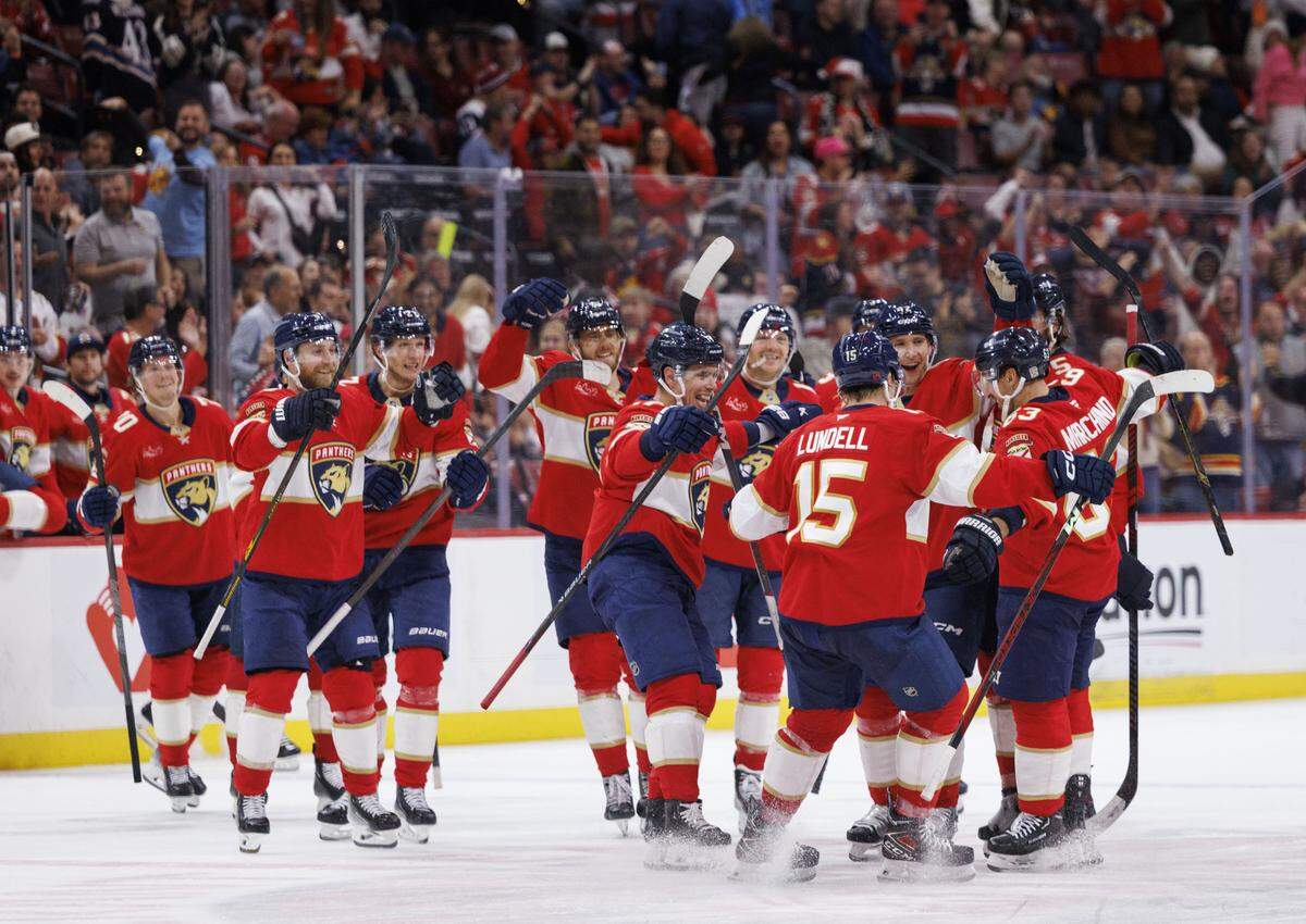 Florida Panthers left wing Brad Marchand (63), right, gets greeted by teammates on the ice after hitting 1000 career points during the third period of a game on Thursday, Nov. 13, 2025, at Amerant Bank Arena in Sunrise, Fla. The Florida Panthers won against the Washington Capitals 6-3. 