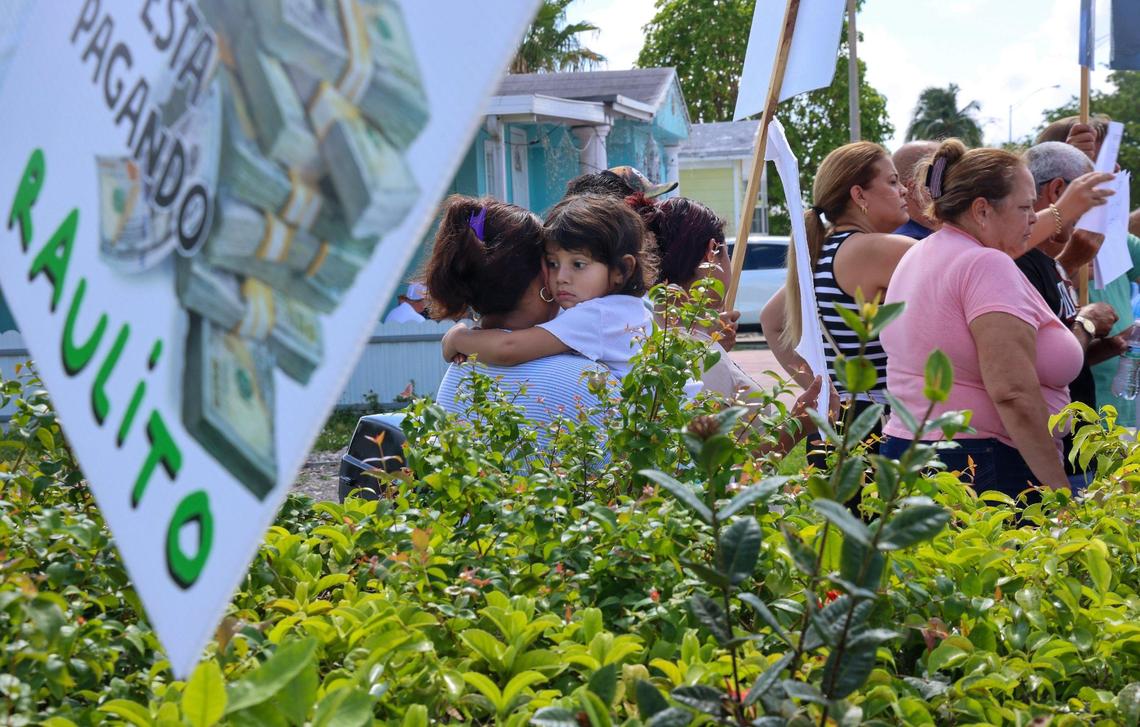 A young girl clings to a resident as mobile home owners rally against pending evictions at Li’l Abner Mobile Home Park in Sweetwater, Florida, on May 19, 2025.