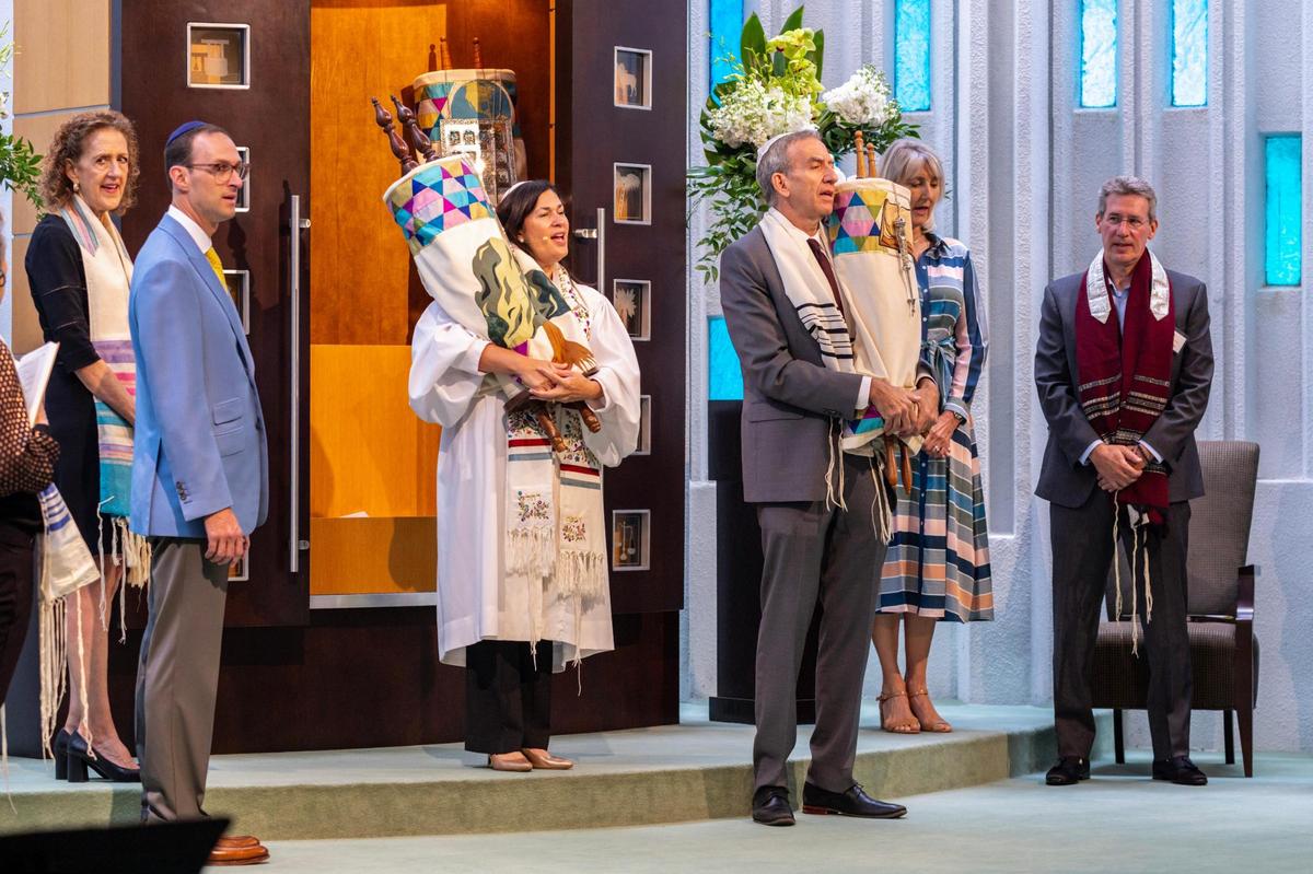 Temple Judea Rabbi Judith Lazarus Siegal and Mark Kass, the synagogue’s president, hold the Torah wrapped in mantles, the handcrafted Torah covers.