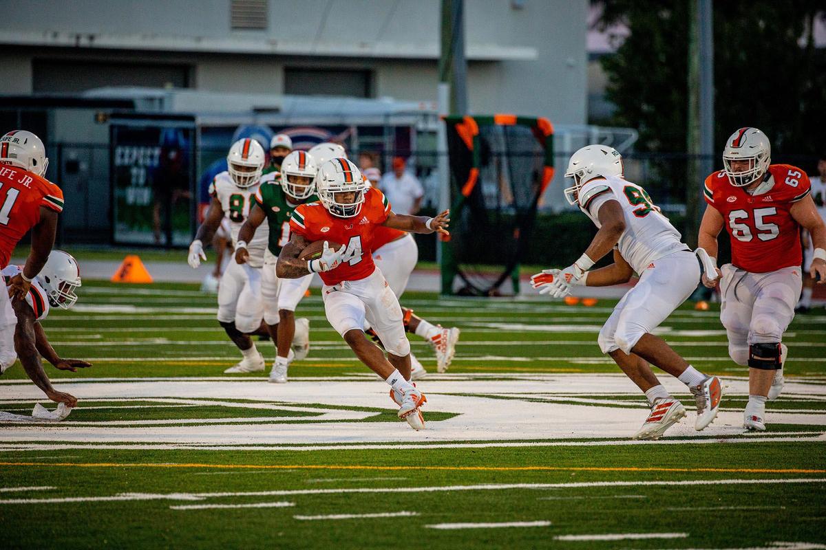 Jaylan Knighton (4) runs against the UM defense during UM’s scrimmage on Sunday, August 16, 2020.