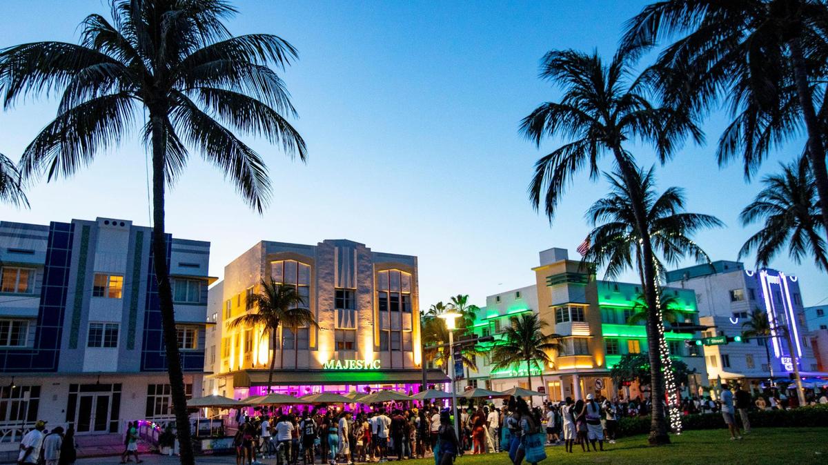 Hoteliers, retailers and restaurateurs face the biggest challenges in Miami’s commercial real estate market. In this photo, crowds huddle around a speaker and dance in the street in front of the Majestic Hotel before curfew on Ocean Drive in Miami Beach, on March 28, 2021.