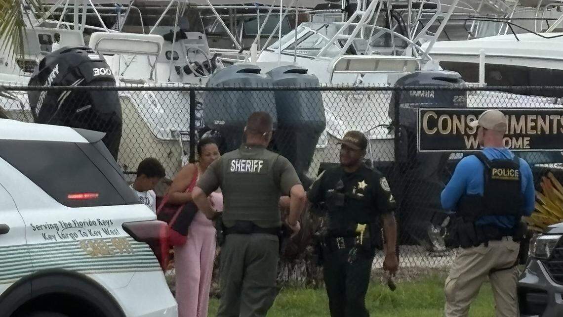 Local, state and federal law enforcement officers stood with a small group of recently arrived migrants in the Florida Keys Thursday afternoon.