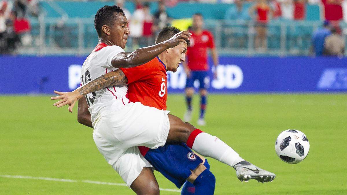 Chile’s Nicolas Castillo (9) fights for control against Peru’s Renato Tapia (13) during a friendly soccer match between Peru and Chile at Hard Rock Stadium in Miami Gardens on Friday, Oct. 12, 2018. 