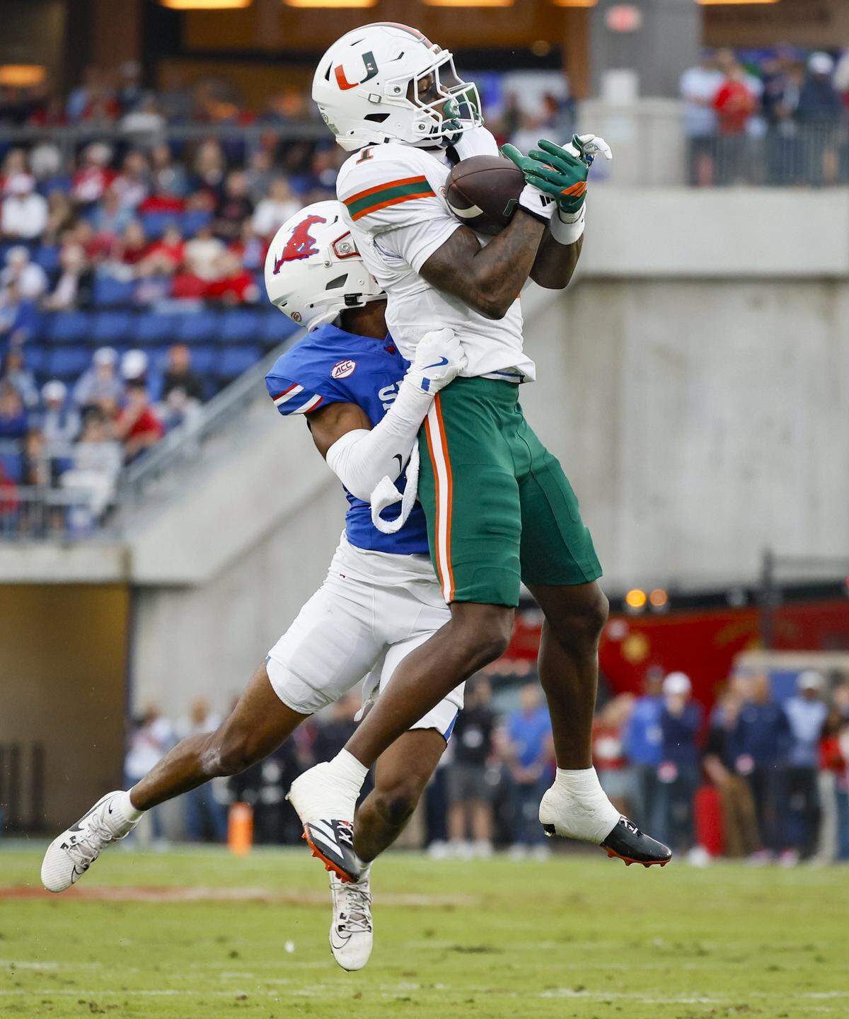 Miami Hurricanes wide receiver Joshisa Trader (1) scores on a pass reception as Southern Methodist University Mustangs cornerback Marcellus Barnes Jr. (8) defends in the first half of an NCAA football game at Gerald Ford Stadium on Saturday, November 1, 2025, in Dallas, Texas.