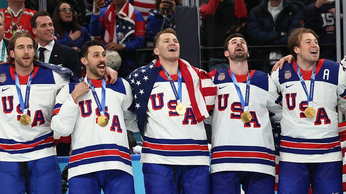 MILAN, ITALY - FEBRUARY 22: Golds medalists Noah Hanifin #15, Vincent Trocheck #16, Matthew Tkachuk #19, Dylan Larkin #21 and Charlie McAvoy #25 of Team United States listen to the national anthem during the medal ceremony for Men's Ice Hockey following their gold-medal win during the Men's Gold Medal match between Canada and the United States on day 16 of the Milano Cortina 2026 Winter Olympic games at Milano Santagiulia Ice Hockey Arena on February 22, 2026 in Milan, Italy. (Photo by Bruce Bennett/Getty Images)