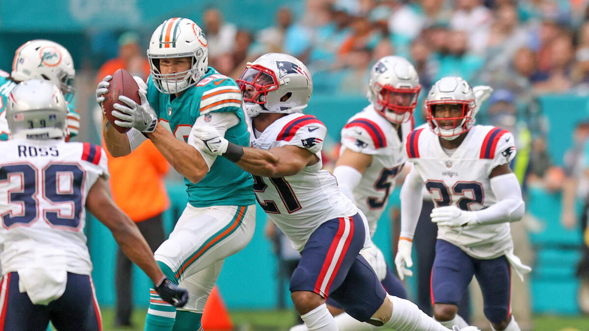 El tight end de los Dolphins Mike Gesicki (88) corre contra la defensa del safety de los Patriots de New England Adrian Phillips (21), en el partido celebrado en el Hard Rock Stadium, el 9 de enero de 2022, en Miami Gardens, Florida. 