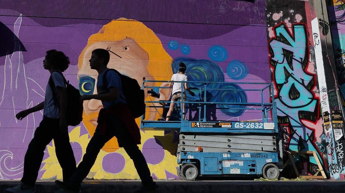 Muralist Cloe Hakakian spray paints her art on the side of a building as the Wynwood neighborhood prepares for the annual Art Basel art fair on Dec. 03, 2018, in Miami. Artists and art lovers from around the world flock to the Miami area from Dec. 6 to the 9th to visit Art Basel as well as the satellite galleries that pop up throughout the city during the week.