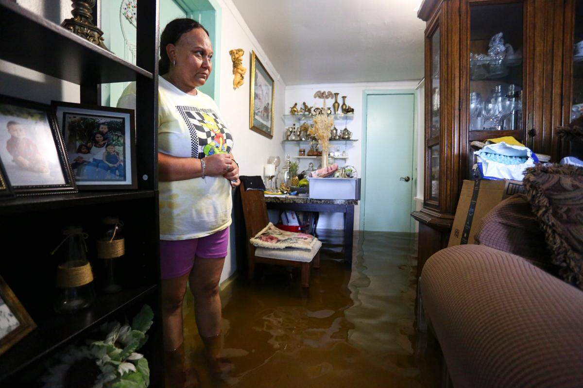 Magda Murillo, que vive en SW Third Street, de pie en el salón de su casa inundada en el barrio de La Pequeña Habana en Miami, Florida, el sábado 4 de junio de 2022.