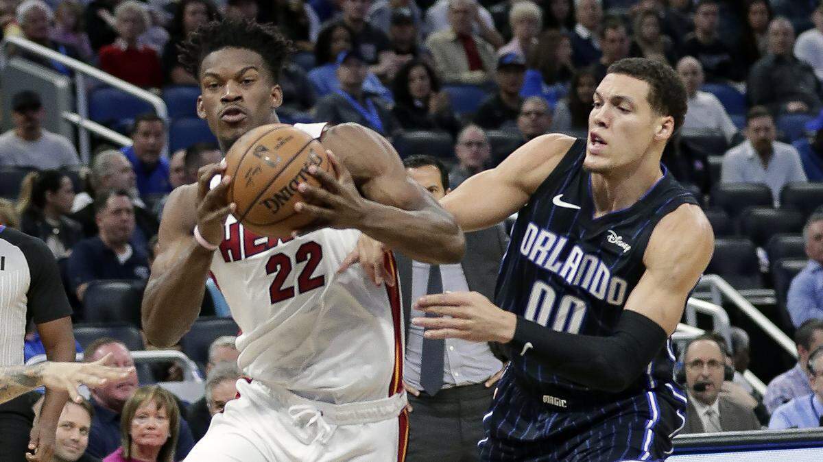 Miami Heat forward Jimmy Butler (22) moves the ball past Orlando Magic forward Aaron Gordon (00) during the first half of an NBA basketball game, Saturday, Feb. 1, 2020, in Orlando.