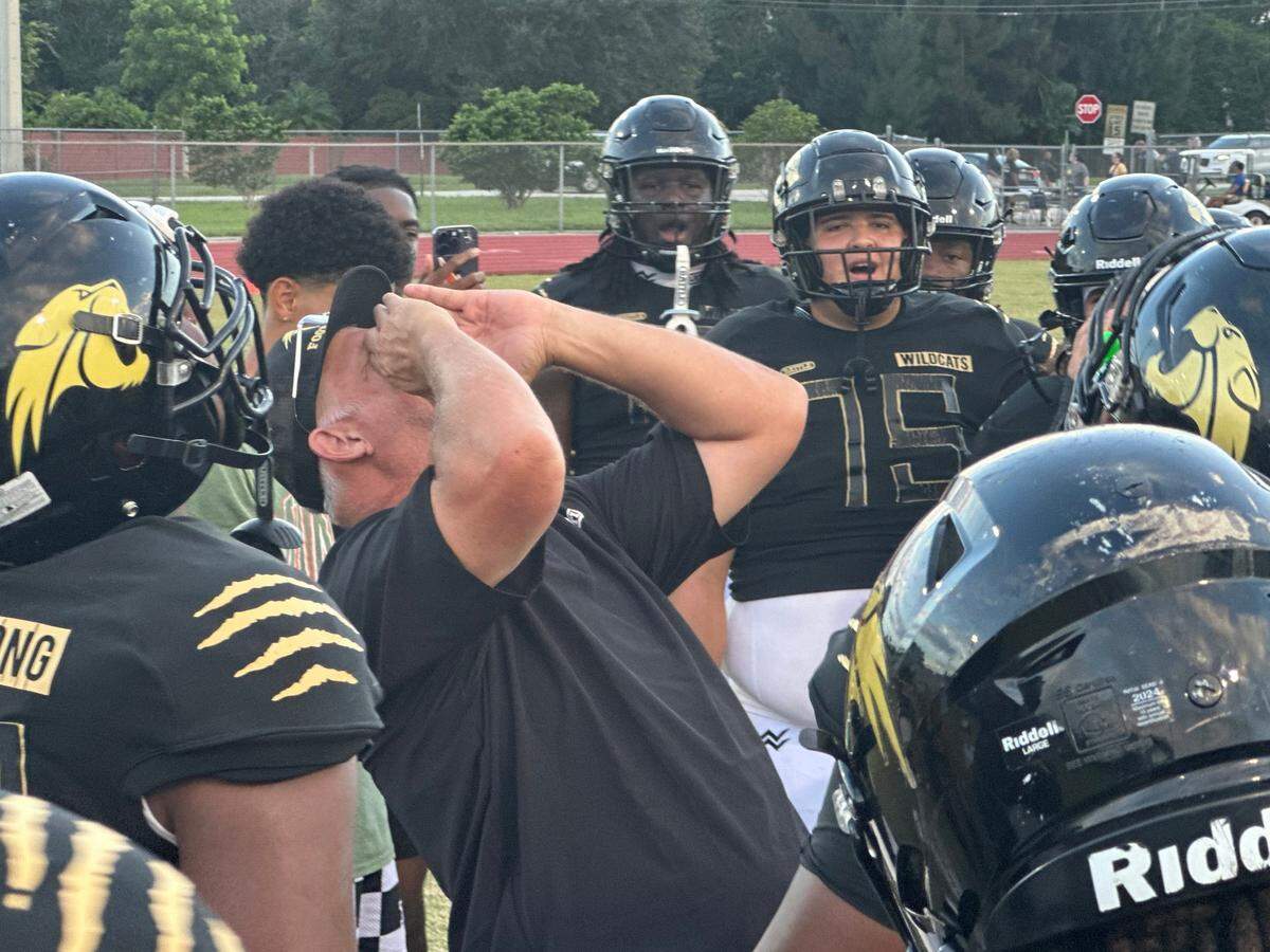 Western High football coach Adam Ratkevich (middle) fires up his team just before playing against West Boca Raton on Friday night at their home field in Davie, Fla.