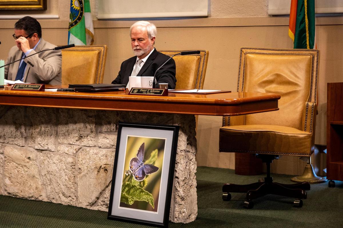 City Manager Peter Iglesias’ empty chair, right, in the Coral Gables Commission chambers after he was fired on Tuesday, February 13, 2024, next to Commissioners Kirk Menendez, center and Ariel Fernandez, left.