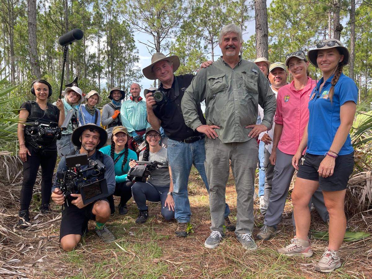 George Gann of The Institute for Regional Conservation (IRC) and Joel Sartore of the National Geographic Photo Ark with representatives from IRC, Zoo Miami, and the U.S. Fish and Wildlife Service Florida pine rockland team, along with representatives from National Geographic and the U.S. Coast Guard. 