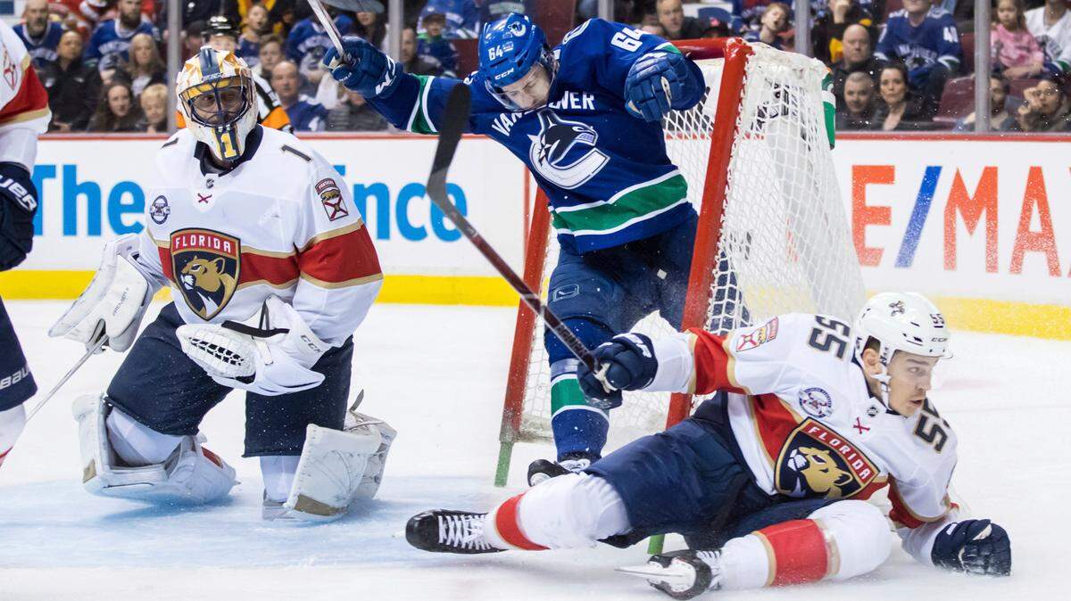 Vancouver Canucks’ Tyler Motte (64) crashes into the net behind Florida Panthers goalie Roberto Luongo (1) after having the puck taken away by Bogdan Kiselevich (55), of Russia, during the second period of an NHL hockey game in Vancouver, British Columbia, Sunday, Jan. 13, 2019.