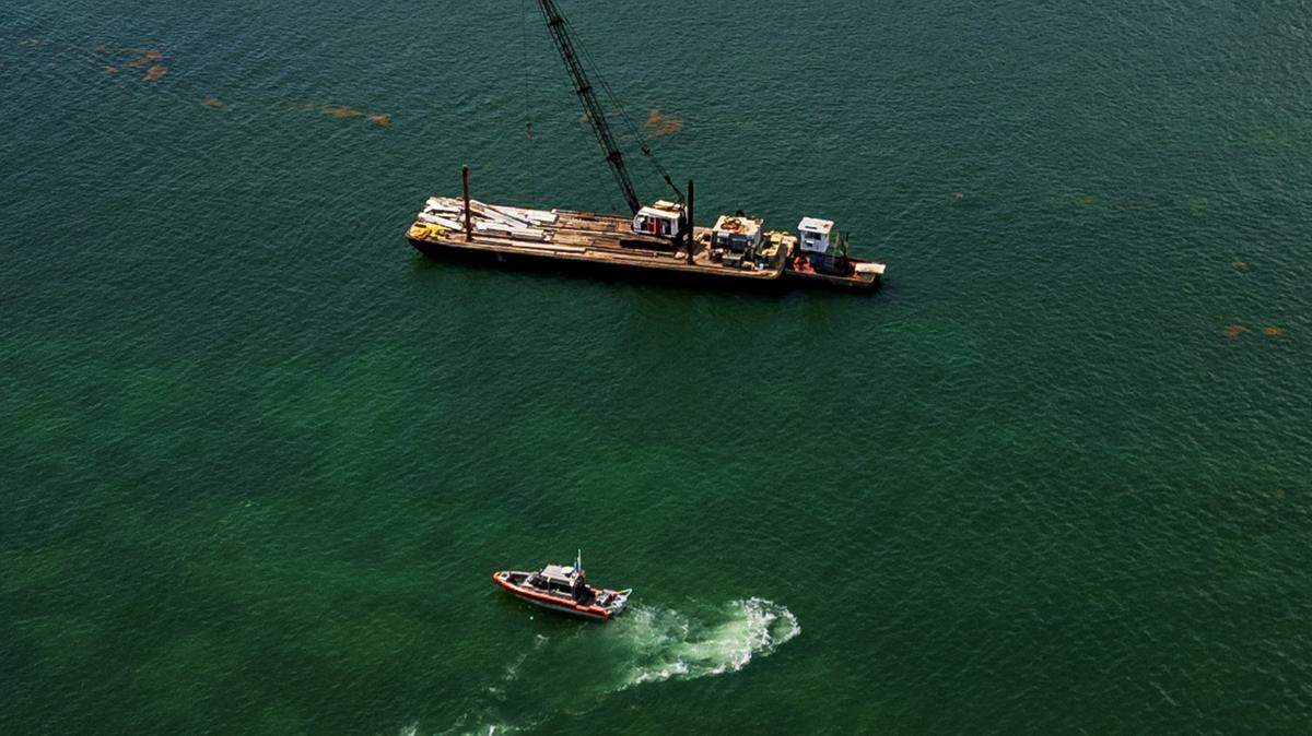 A US Coast Guard vessel is seen next to a barge that hit a sailboat that sank off Miami Beach’s Hibiscus Island in Biscayne Bay Monday morning, July 28, 2025. Five children and a camp counselor were aboard the sailboat, part of a Miami Yacht Club summer camp. Three of the girl capers died from the collision.