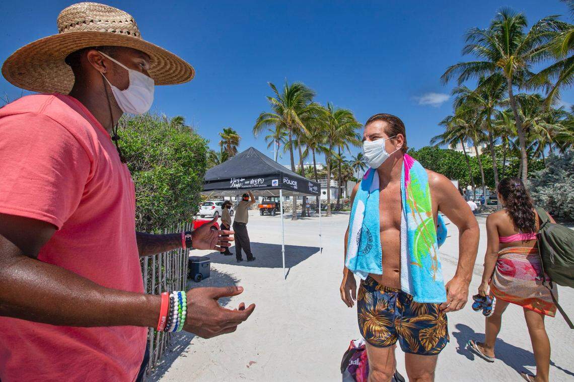 Deandre Asbury-Heath, a “safe-distancing beach ambassador,” speaks with actor Vincent De Paul about beach regulations along Ocean Drive and 10th Street as Miami-Dade County reopened beaches Wednesday, June 10, 2020, following coronavirus closures.