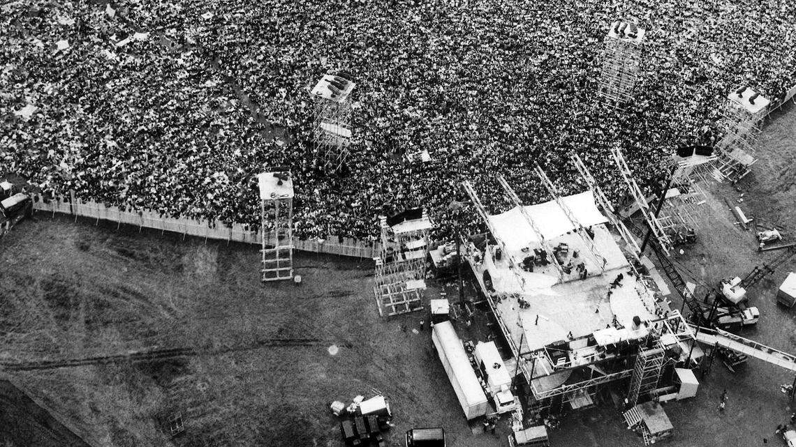 In this Aug. 16, 1969 file aerial photo, music fans pack around the stage at the original Woodstock Music and Arts Festival, lower right, in Bethel, New York. The Bethel Woods Center for the Arts, a concert venue built on the original Woodstock site, announced Thursday, Dec. 27, 2018, that it will host the 50th anniversary of the historic event at the original Woodstock concert site on Aug. 16-18, 2019.