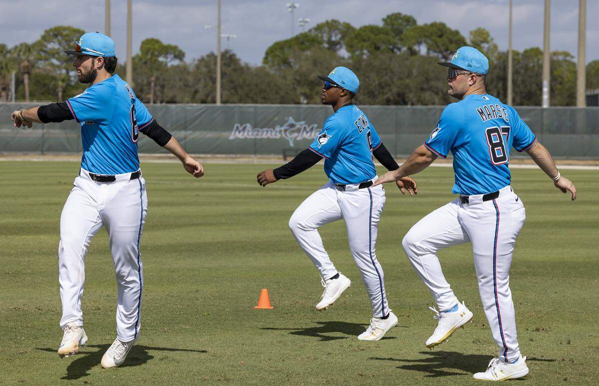 Miami Marlins catcher Joe Mack (80), shortstop Xavier Edwards (9) and center fielder Jakob Marsee (87) run drills during the team's first full-squad spring training workout at Roger Dean Stadium on Monday, Feb. 16, 2026, in Jupiter, Fla.