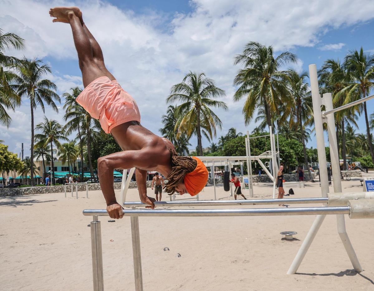 El masajista e instructor de yoga Anthony Hazin, de 31 años, haciendo ejercicio en My Equilibra, un parque de bienestar, bajo el sol de las 12:00 p.m., cuando la temperatura superaba los 90 grados en Miami Beach, la Florida.