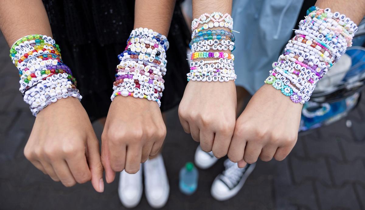 Suki Sidhu, 20, left, and her sister, Risham Sidhu, 25, show their friendship bracelets as they arrive to Hard Rock Stadium to watch Taylor Swift’s The Eras Tour on Friday, Oct.18, 2024, in Miami Gardens, Fla.