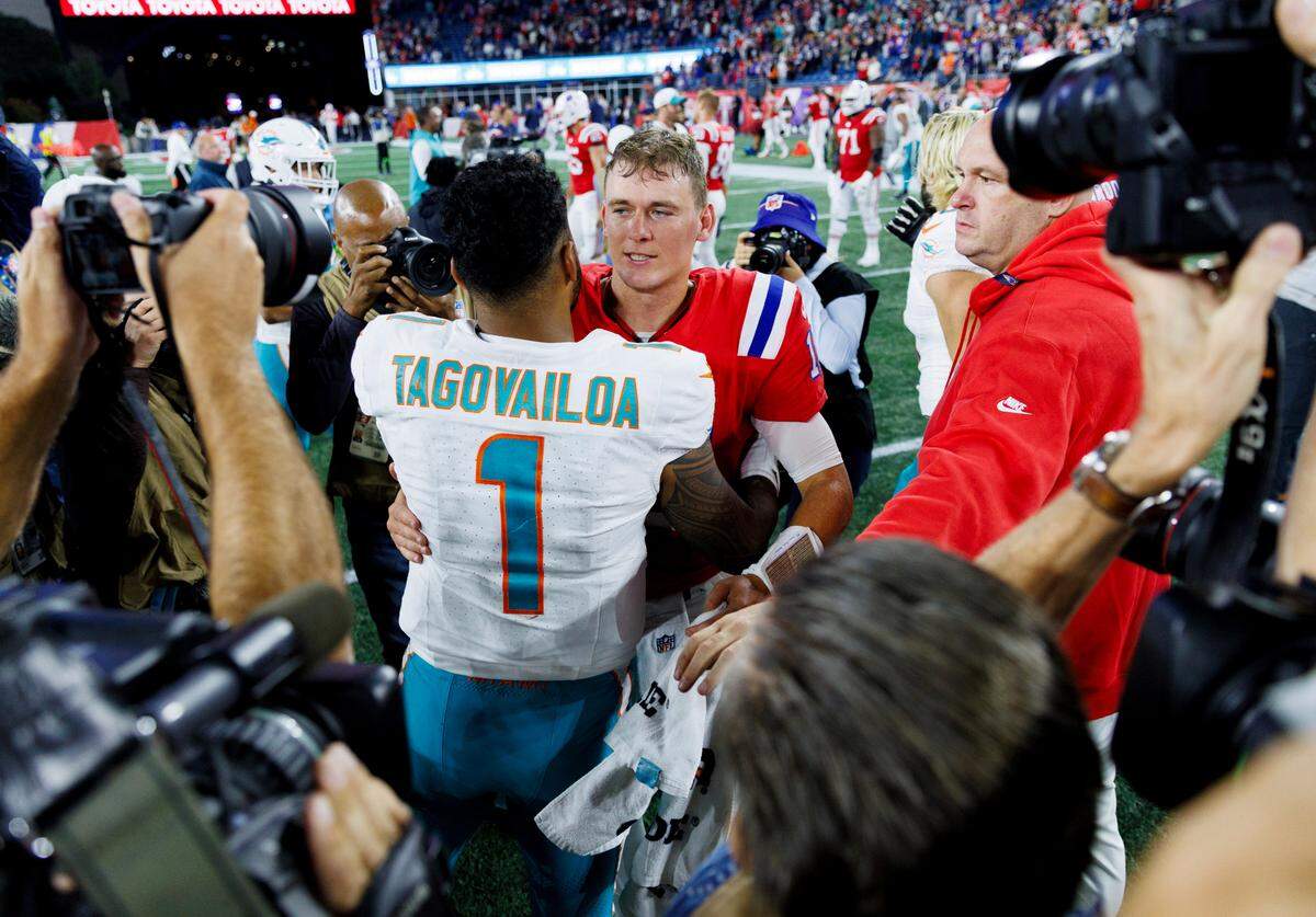 Miami Dolphins quarterback Tua Tagovailoa (1) hugs New England Patriots quarterback Mac Jones (10) after the Dolphins 24-17 win over the Patriots during an NFL football game at Gillette Stadium on Sunday, Sept. 17, 2023 in Foxborough, MA.