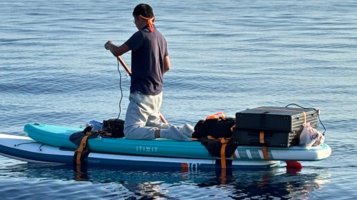 A man who federal authorities said is Chinese rows a paddleboard about 25 miles off Freeport, Bahamas, Tuesday, Feb. 4, 2025. The Coast Guard said he was trying to migrate to the United States.