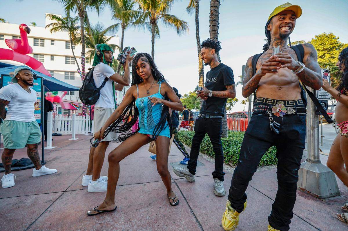 Spring breaker Taylor Harvin dances on the sidewalk outside the in front of the Clevelander Hotel during Spring Break along Ocean Drive, Miami Beach, Florida on Friday, March 14, 2025.