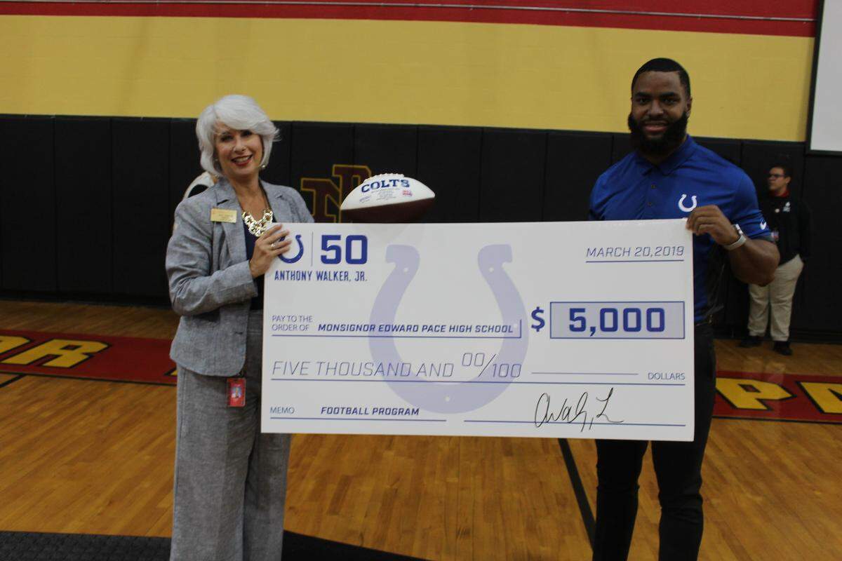 Monsignor Pace Principal Ana Garcia proudly accepted a check for $5,000 from former Indianapolis Colts LB and former Pace standout Anthony Walker Jr at a ceremony on March 20, 2019 in which Walker’s jersey was retired. Walker now plays for the Miami Dolphins. 