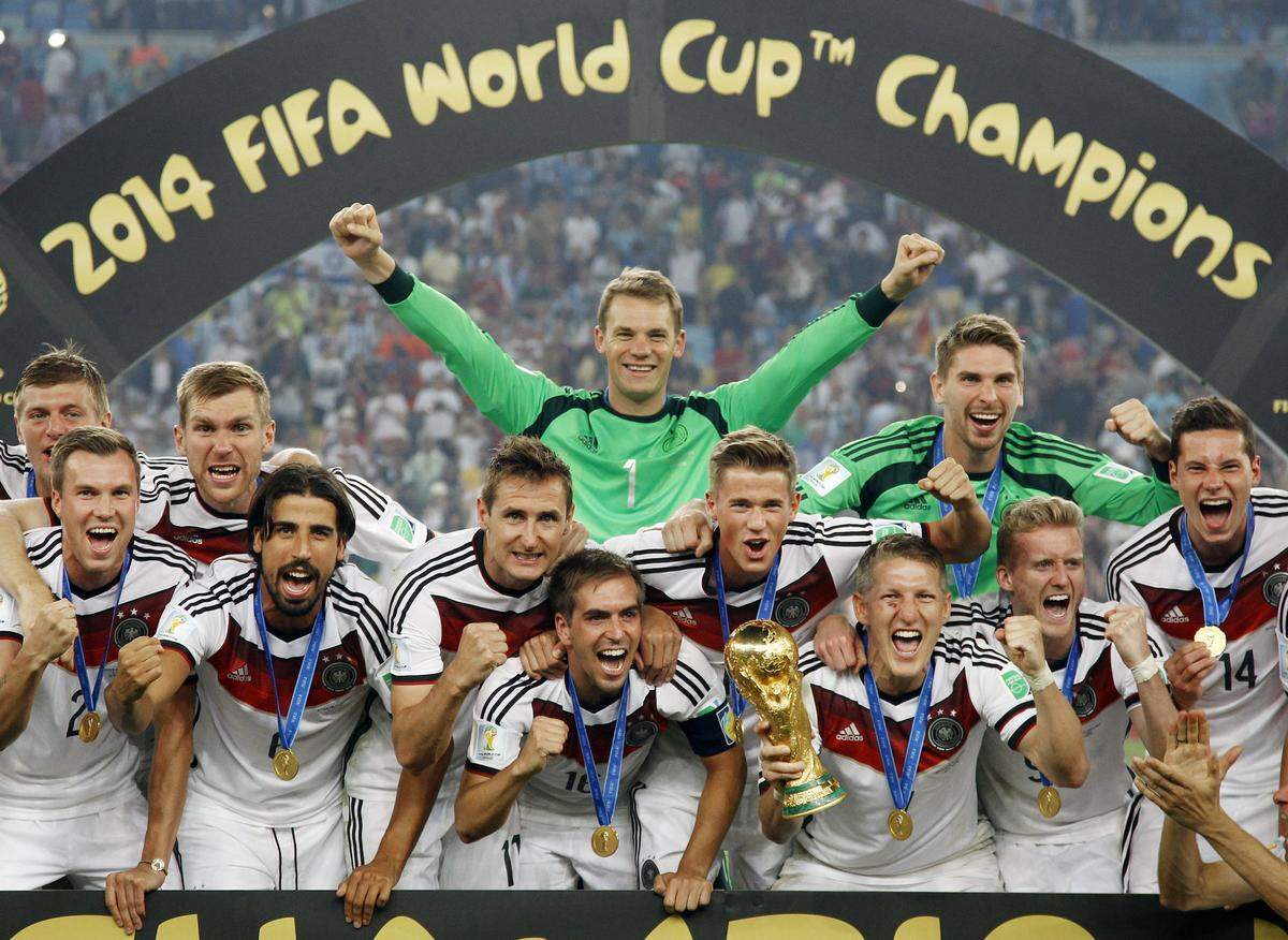 FILE - In this July 13, 2014 file photo German players celebrate with the trophy after the World Cup final soccer match between Germany and Argentina at the Maracana Stadium in Rio de Janeiro, Brazil. Germany coach Joachim Loew is brimming with confidence just over three weeks before what he calls the country’s “golden generation” begins its World Cup defense against Mexico. (AP Photo/Matthias Schrader, file)
