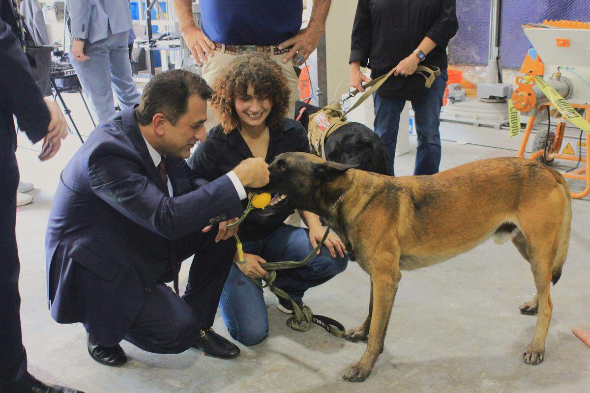 Associate Professor at Florida International University, Pezhman Mardanpour, and Lucila Santoni of Innovative Detection Concepts play with corrosion-sniffing dog, Loki, at Florida International University’s engineering campus on May 29, 2026.