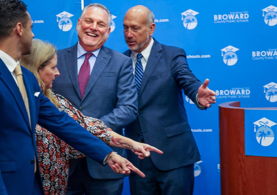 Superintendent Peter Licata, center, breaks into laughter as School Board members points to where he must stand for a group picture at the Kathleen C. Wright Building in Fort Lauderdale, Florida on Tuesday, July 11, 2023. Left to Right: School Board members Daniel Foganholi, Debra Hixon and Allen Zeman. On Tuesday, April 16, 2024, Licata announced his retirement.