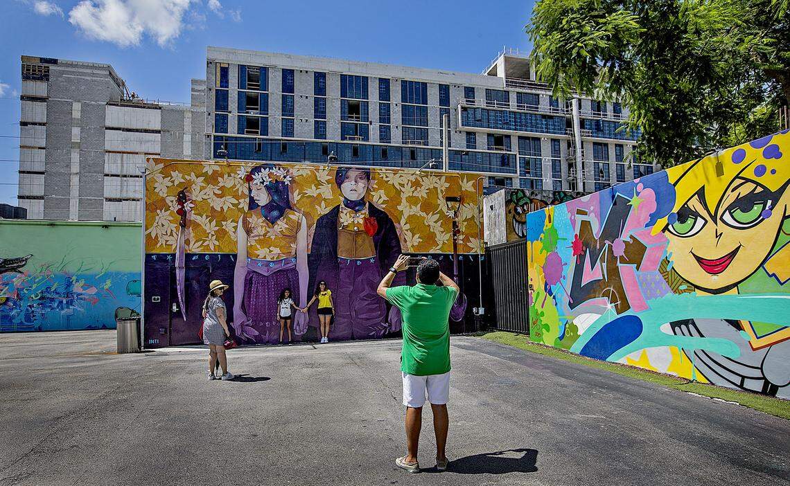 A visitor from Colombia takes a picture at Wynwood Walls in 2018 with the Wynwood 25 apartment complex under construction on Northwest 25th Street.