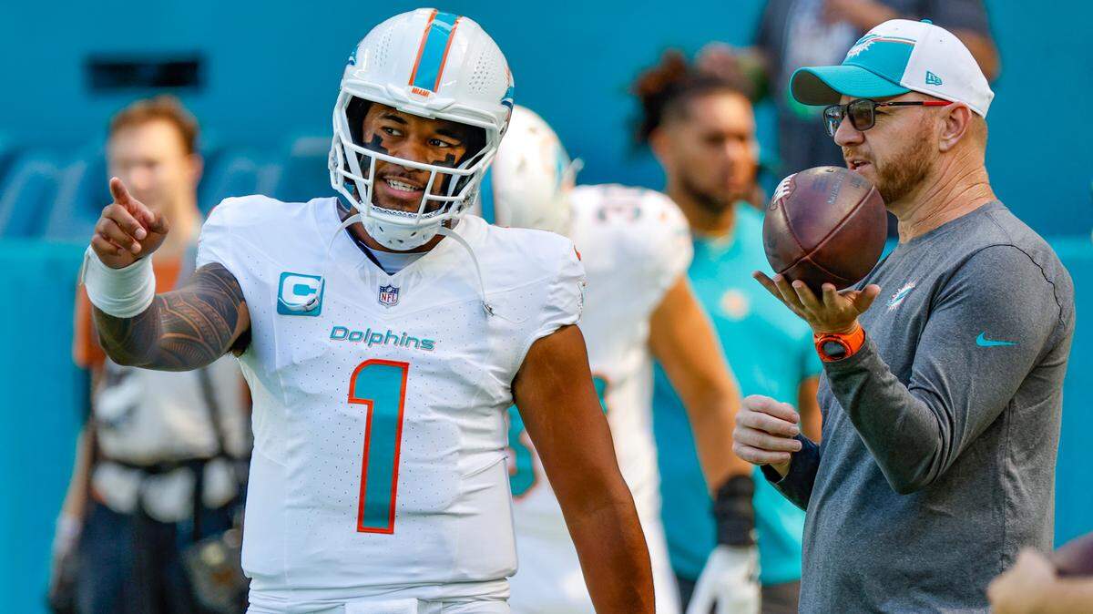 Miami Dolphins quarterback Tua Tagovailoa (1) talks with quarterbacks and passing game coordinator coach Darrell Bevell before the game against the Carolina Panthers at Hard Rock Stadium in Miami Gardens on Sunday, October 15, 2023.