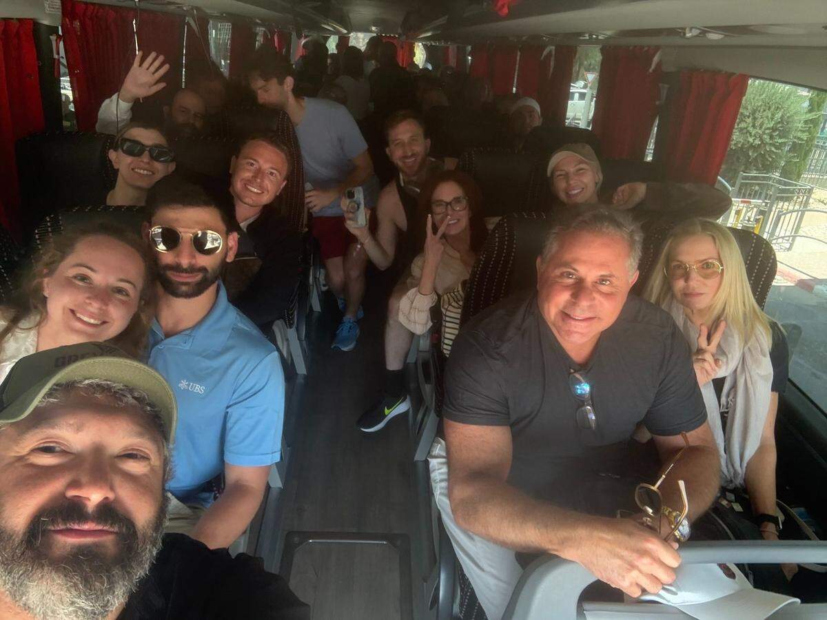 El fundador de Grey Bull Rescue, Bryan Stern, con una gorra en la parte inferior izquierda, se toma una foto con el primer grupo al que su grupo ayudó a evacuar Israel mientras aumentan las tensiones con Irán en junio de 2025.