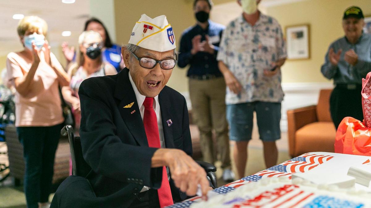 El veterano del Ejército de Estados Unidos Richard Goon (centro), de 98 años,  parte un pastel después de ser galardonado con la Medalla de Oro del Congreso en una ceremonia virtual en la Grand Villa Senior Living Community el 5 de julio de 2022 en Deerfield Beach, Florida.