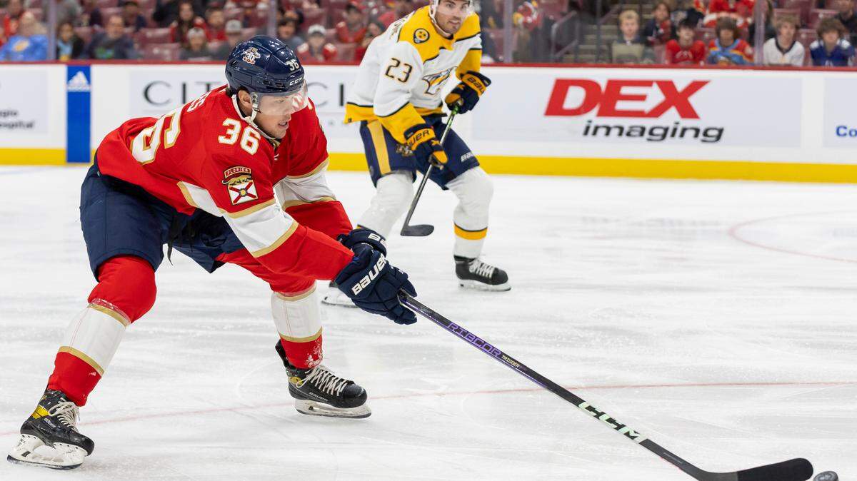Florida Panthers forward Patrick Giles (36) skates with the puck as Nashville Predators defenseman Jake Livingstone (23) defends in the first period of their NHL preseason game at the Amerant Bank Arena on Monday, Sept. 25, 2023, in Sunrise, Fla.
