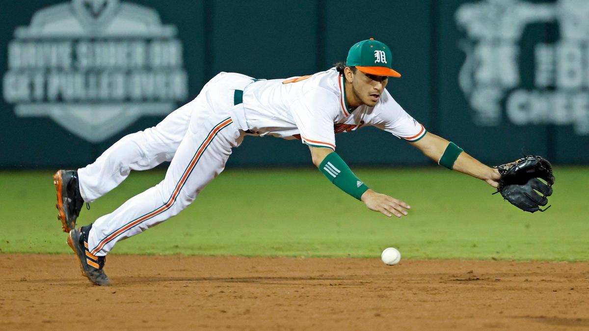 Miami Hurricanes infielder Dominic Pitelli (19) chases a ground ball hit by Penn State outfielder Johnny Piacentino (22) in the second inning at Mark Light Field at Alex Rodriguez Park in Coral Gables, Florida on Friday, February 17, 2023.