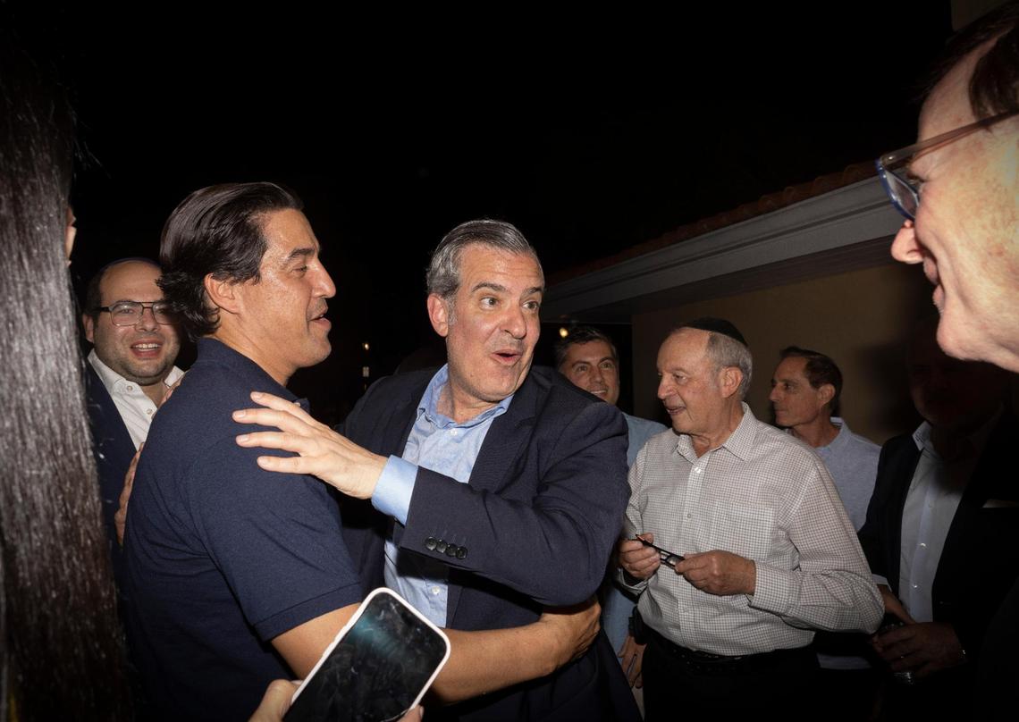 Steven Meiner, the newly elected mayor of Miami Beach, embraces Andres Asion as Meiner arrives at a watch party on Tuesday, Nov. 21, 2023.