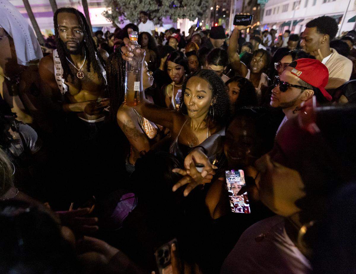 A crowd of people dance on Ocean Drive during spring break on Saturday, March 11, 2023, in Miami Beach, Fla.