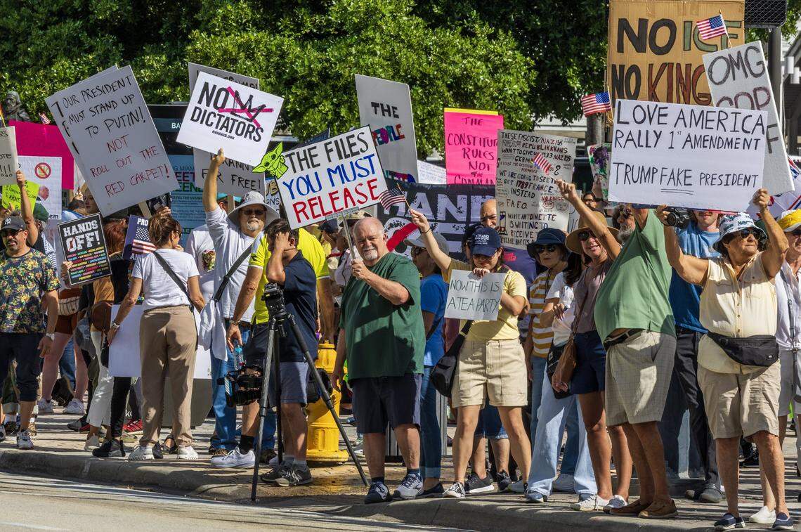 Protesters with signs at the Miami Torch of Friendship in downtown Miami during the ‘No Kings’ anti-Trump protests on Oct. 18, 2025.