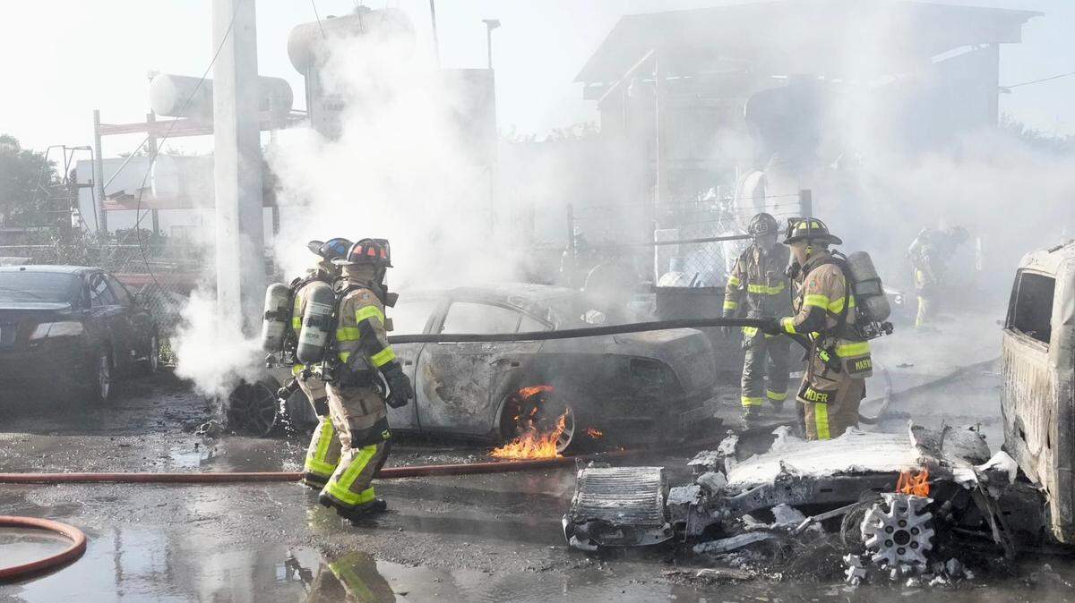 Bomberos de Miami-Dade trabajan en el lugar donde varios vehículos se incendiaron en 11350 NW South River Dr. el 21 de febrero de 2023.