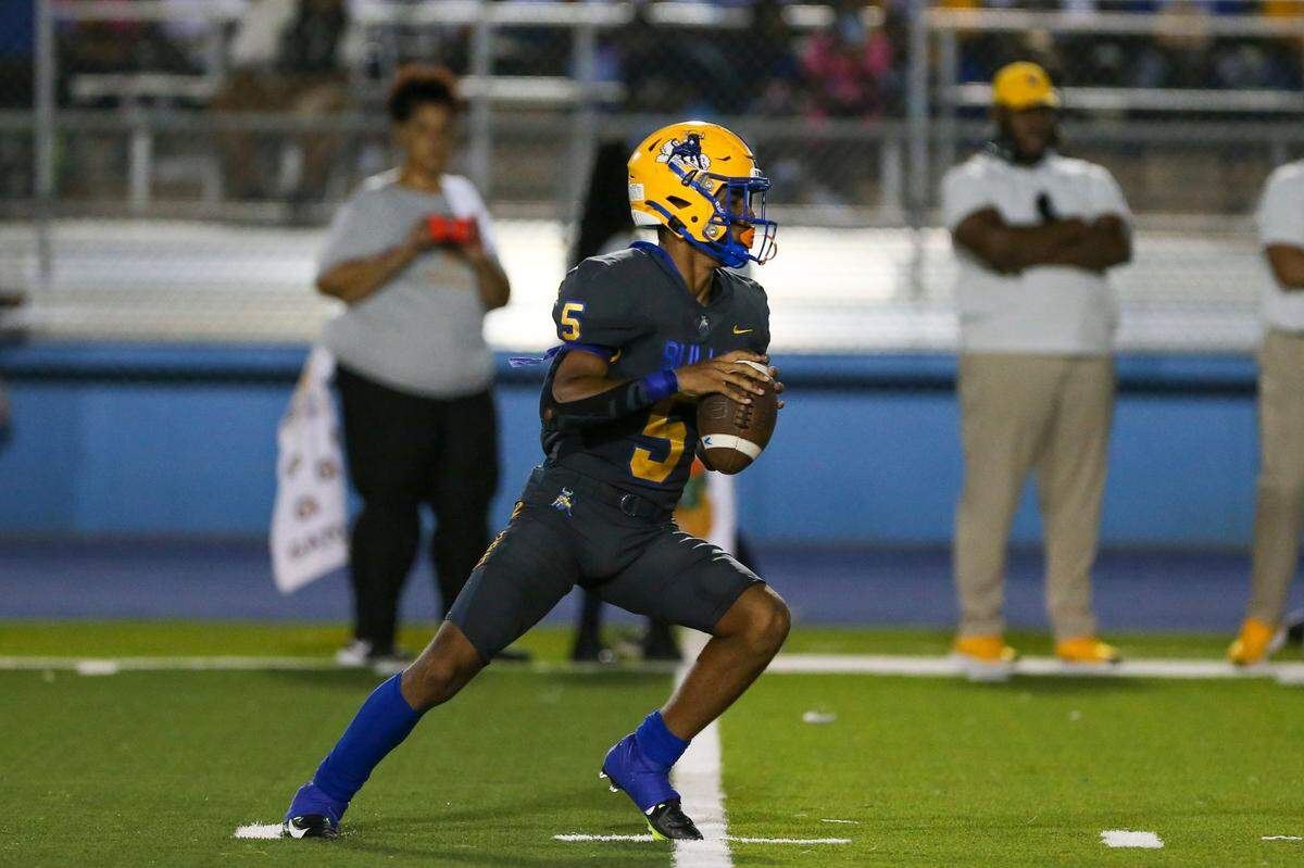 Northwestern Bulls quarterback Taron Dickens (5) hols the football prior to attempting a pass during the second quarter of a high school football game against the Jackson Generals at Traz Powell Stadium in Miami, Florida, on Friday, September 1, 2022.
