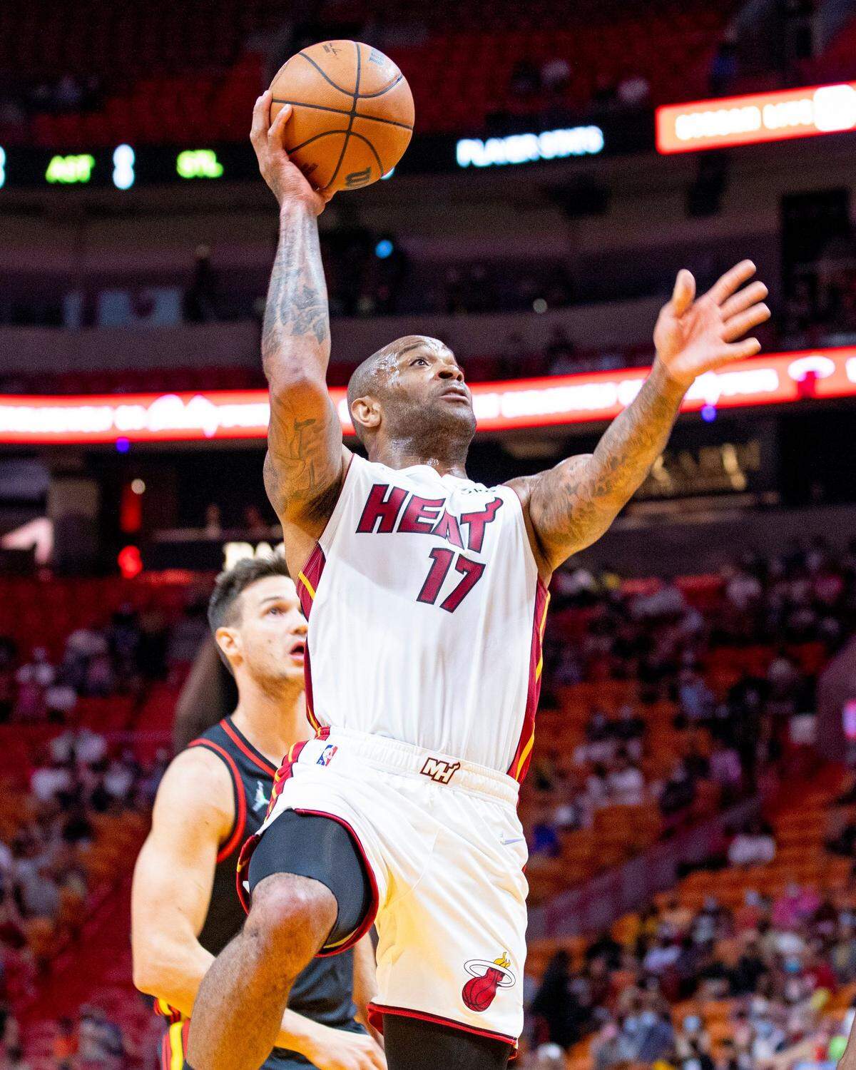 Miami Heat guard forward P.J. Tucker (17) attempts a layup over an Atlanta Hawks player during an NBA preseason game at FTX Arena in Downtown Miami, Florida, on Monday, October 4, 2021.